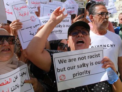 People lift placards as they shout slogans during a demonstration against the presence of illegal sub-Saharan migrants, in Sfax on June 25, 2023. Sfax, the second largest city in Tunisia, is the starting point for a large number of illegal migrants trying to reach Italy. (Photo by HOUSSEM ZOUARI / AFP)